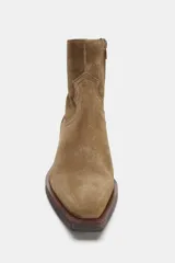 Botín estilo cowboy confeccionado en serraje, con detalle de pespuntes en el cuerpo, cierre lateral mediante cremallera y acabado en punta con tacón cuadrado.