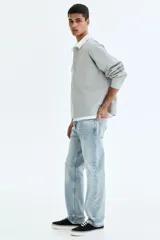Jean de cinco bolsillos en denim de algodón con lavado claro y leve efecto desteñido. Modelo de cintura clásica, con cierre frontal y corte recto de pierna holgada.
