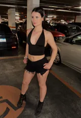 Short de denim negro de tiro medio, con bolsillos delanteros y traseros, pasatintos y dobladillo desmechado con flecos.