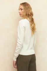 Polera color borgoña de tejido de punto con cuello alto y mangas largas.