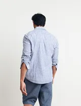 Camisa de lino a rayas verticales color beige y blanco, de corte clásico, con cuello abotonado y mangas largas.