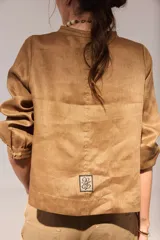 Blusa de lino color marrón con cuello mao, escote en V y mangas largas.