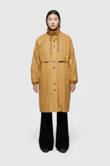 Chaqueta larga color marrón de corte holgado, confeccionada en tejido encerado lavado. Incluye chaleco interior extraíble en nailon ligero acolchado.