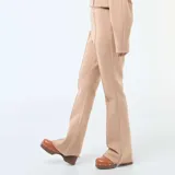 Pantalón de felpa ligera en color beige, con corte bootcut y costura central vertical en el frente de cada pierna.