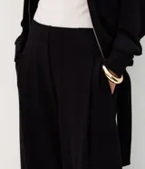 Pantalón wide leg negro con diseño a rayas sutiles, tiro medio, pinzas frontales y caída fluida.