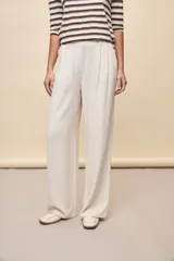 Pantalón negro de pierna ancha y calce fluido, con pinzas delanteras y bolsillos laterales.
