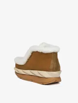 Bota marrón de cuero con forro de borrego blanco, plataforma ondulada y suela de goma.