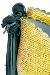 Botín de piel tornasolada con acabado brillante en tono amarillo lima y reflejos verdes. Presenta un diseño de dos piezas con bordes troquelados, aberturas laterales, ajuste con elásticos y un borlón decorativo de ante verde en la parte trasera. Incluye cuña interna y suela de cuero.