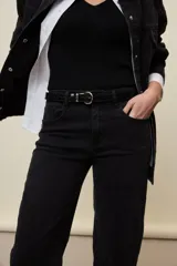 Jeans de corte straight y tiro medio, color negro, confeccionados en denim con spandex. Presenta un sutil tajo en la parte inferior del ruedo.