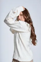 Sweater color crema de hilado frizado con cuello redondo y apliques de flores color beige en las mangas.