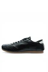 Championes casuales Vetter para mujer, de color negro con una franja lateral blanca en forma de V y suela de goma marrón. Presentan cordones negros y detalles pespunteados en la puntera.