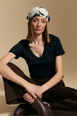 Remera de manga corta en tejido acanalado, con escote en V y detalles de puntilla en el borde del escote y en las mangas. Presenta un ajuste entallado al cuerpo.