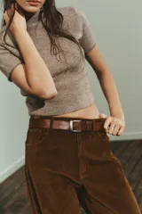 Jersey de punto de tacto suave, color gris jaspeado, con cuello subido y manga corta.