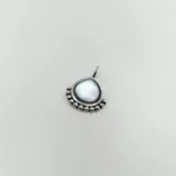 Dije de plata 925 con forma de gota, engastado con una piedra de nácar central y detalle de pequeñas esferas metálicas en el borde inferior.