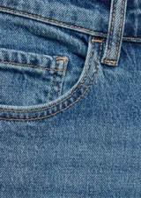 Jeans de corte mom-fit con tiro alto, confeccionados en tejido de algodón con un toque de elasticidad. Presentan diseño clásico de cinco bolsillos, cierre de cremallera con botón y trabillas para cinturón.