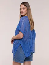 Poncho de tejido calado color beige, con mangas cortas, aberturas laterales y lazos ajustables en el cuello. Modelo Do Everything In Love.