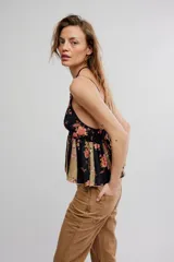 Top estilo babydoll de viscosa color rosado con estampado floreado, escote en V pronunciado, tirantes finos y detalles de volados combinados con paneles en tono crudo.