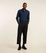 Camisa blanca de corte regular, confeccionada en tejido Oxford de algodón, con cuello inglés, mangas largas y cierre frontal abotonado.