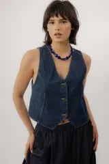 Chaleco de denim azul oscuro con pespuntes amarillos en contraste, escote en V y cierre frontal con botones metálicos.