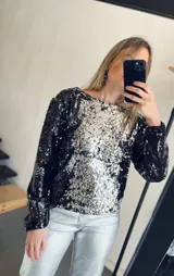 Blusa de manga larga con lentejuelas negras y plateadas, forrada y con escote en V en la espalda.