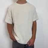 Remera de lino color beige, de corte regular, con cuello redondo y mangas cortas.