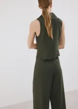 Camisa sin mangas de lino y algodón color verde militar, con cuello solapa y cierre frontal con múltiples lazos.