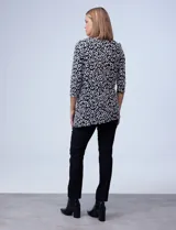 Blusa azul con estampado de círculos negros, de tejido texturado con escote en V descentrado y aplique de aro metálico.
