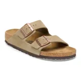 Sandalia Birkenstock modelo Arizona de dos correas ajustables con hebillas metálicas. Confeccionada en gamuza color taupe, con plantilla anatómica de corcho y suela de goma.