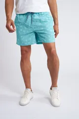 Short de baño con cintura elástica y cordón ajustable, confeccionado en tela ligera de secado rápido. Presenta un estampado botánico integral en tonos amarillos, blancos y azules, con dos bolsillos delanteros y uno posterior.