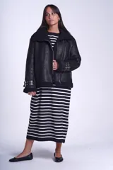 Campera gamulán marrón de símil cuero, con interior de corderoy al tono, cierre frontal con cremallera y cuello con solapas grandes. Presenta detalles de hebillas en los puños y bolsillos laterales con cierre.