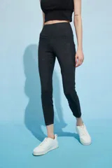 Calza deportiva larga color verde azulado con pretina alta y bolsillos laterales.