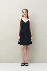 Camisón de pijama negro de tejido satinado con leve elasticidad, escote en V, recorte bajo busto y tiras finas regulables.