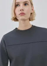 Buzo gris oscuro de piqué, de cuello redondo y manga larga con puños ajustados, con detalle de costura horizontal en el pecho.