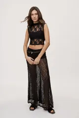 Falda larga de encaje negro semitransparente, de tiro medio y diseño amplio con textura floral.