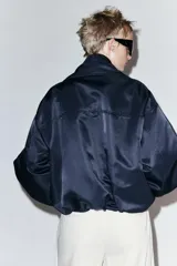 Chaqueta bomber negra ZW Collection con acolchado interior, cuello envolvente de solapa cruzada, mangas largas con puños elásticos y bajo con elástico.