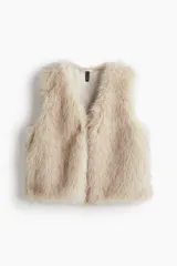 Chaleco color beige con efecto peludito, cuello en V y cierre oculto de corchete. Forrado.