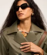 Trench coat de poliuretano color verde militar, con cuello de solapa, diseño cruzado y cierre frontal de doble botonadura.