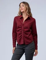 Camisa azul en símil suede, marca Ninety. Cuello con solapa y abertura central con botones. Delantera fruncida.