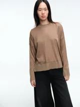 Sweater de tejido fino con hilo brillante, de calce relajado, cuello redondo, hombros caídos y mangas largas amplias con puños ajustados.