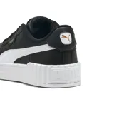 Championes Puma modelo Carina 3.0, de color negro con la franja característica en blanco y suela de plataforma acanalada. Presenta detalles de la marca en dorado.