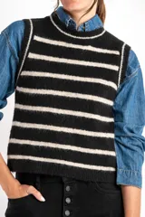 Chaleco de punto negro con rayas horizontales color crema, cuello alto y corte ajustado.