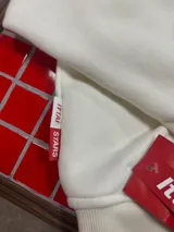 Hoodie de color blanco con capucha, diseño de corte holgado y estampado gráfico en la espalda con tipografía negra.