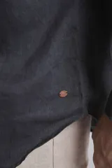 Camisa de lino color marrón, con cuello mao, manga larga y botones blancos.