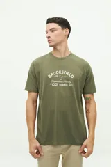 Remera verde militar de manga corta con cuello redondo y estampado frontal con el texto "Brookfield The Emporium of Postmodern Activity No 1001 Torino | 1971".