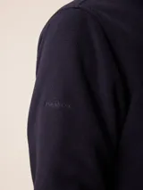 Campera de polar color verde militar, con cierre frontal completo, cuello alto y bolsillo en el pecho con cierre y detalle en tela técnica.