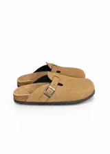 Zuecos de gamuza color beige, con diseño cerrado en la parte delantera, tira ajustable con hebilla metálica y suela de goma con borde de corcho.