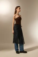 Falda midi negra de poliamida, con diseño de encaje floral y anudado en la cintura.