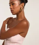 Blusa peplum de viscosa color rosa, con escote strapless, frunces en el busto y volado en la cintura.