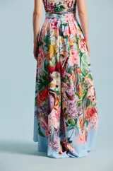 Falda larga con estampado botánico y floral multicolor sobre base celeste, diseño cruzado con volumen y movimiento.