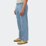 Pantalón de jean celeste de corte holgado, con doble rodilla reforzada y múltiples bolsillos.